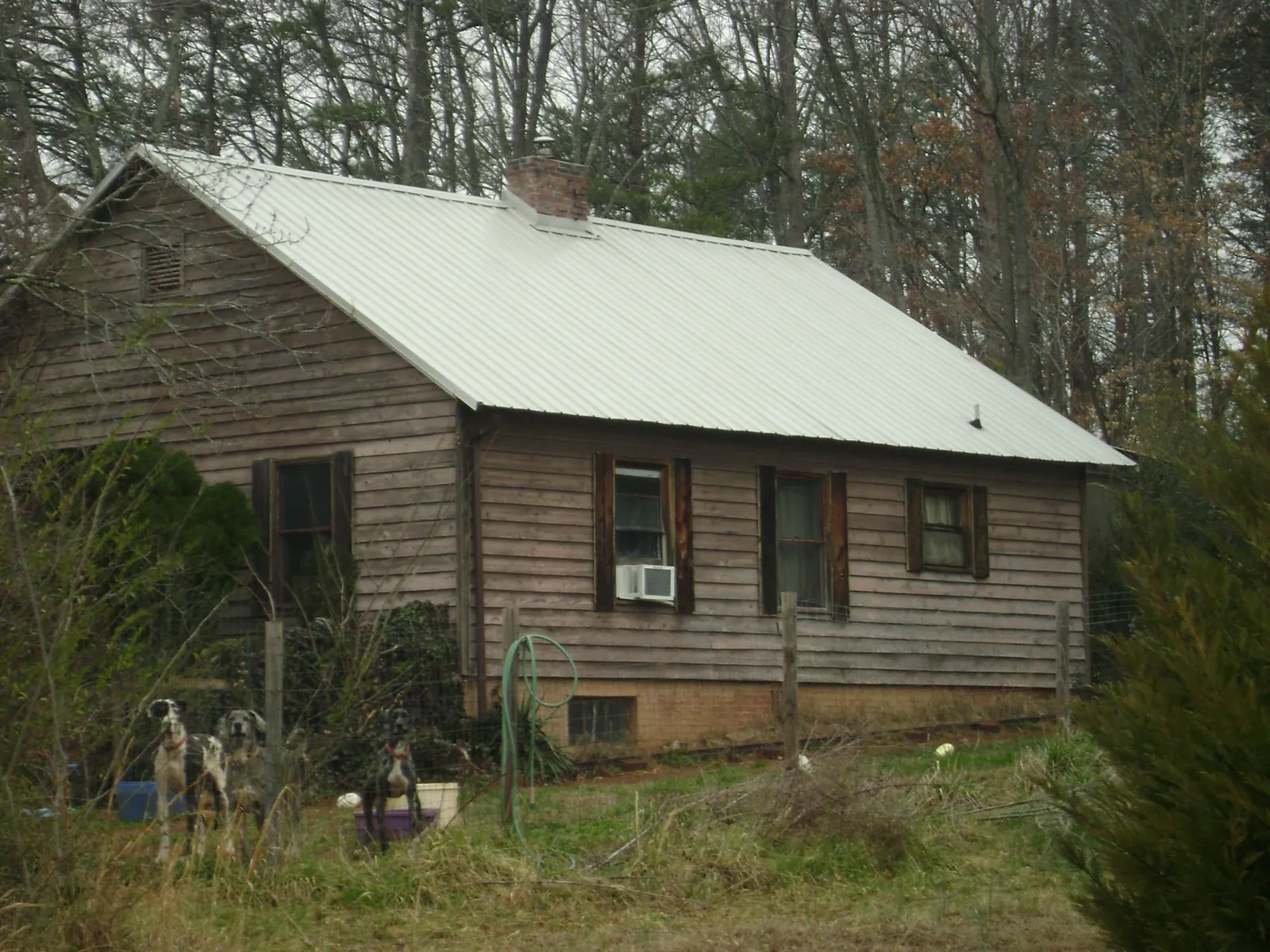 White metal roof on an old wood sided farmhouse, from a Metal Roof Installation job in Grapevine